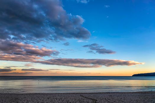 Beautiful colorful clouds over the sea. Amazing sky after sunset.