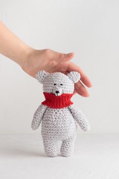 Crochet knitting cute teddy bear with a red scarf