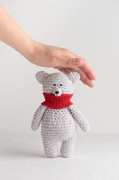Crochet knitting cute teddy bear with a red scarf