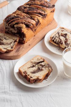 Sweet swirl homemade bread with poppy seeds on a white table