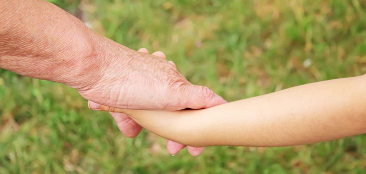 old man holding child's hands. selective focus.People