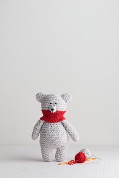 Crochet knitting cute teddy bear with a red scarf