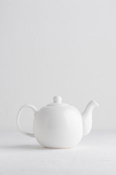 White teapot on a table on a white background