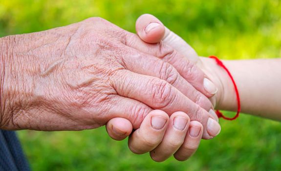 old man holding child's hands. selective focus people
