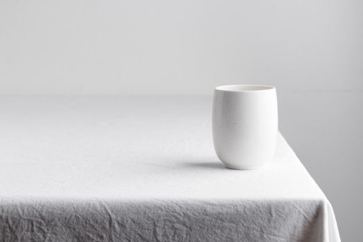 White teacup on a table on a white background