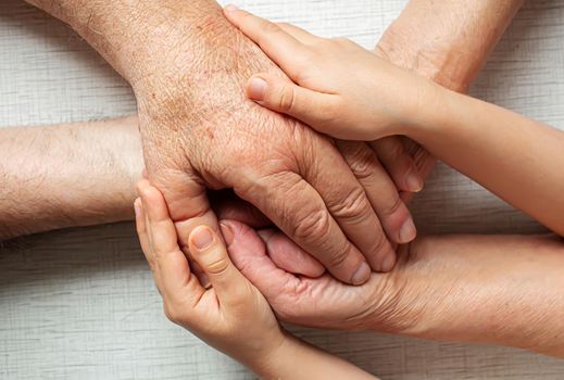 old man holding child's hands. selective focus people