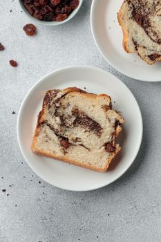 Piece of swirl homemade bread with poppy seeds on a white table