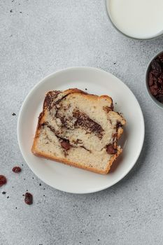 Piece of swirl homemade bread with poppy seeds on a white table