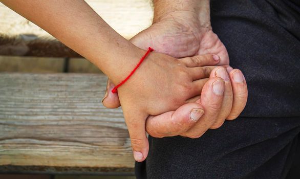 old man holding child's hands. selective focus people