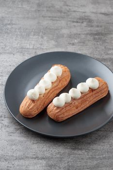 Traditional French dessert sweet eclairs on a gray background