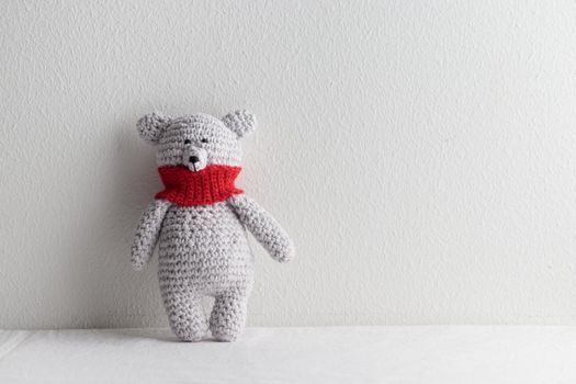 Crochet knitting cute teddy bear with a red scarf