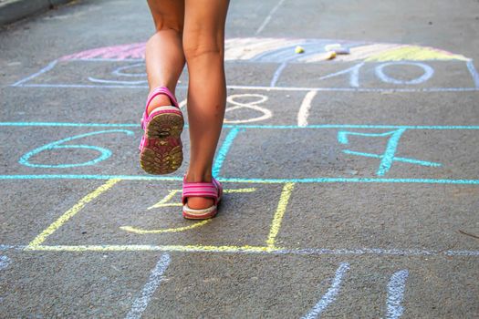 Child jumping classics on the pavement. Selective focus.child