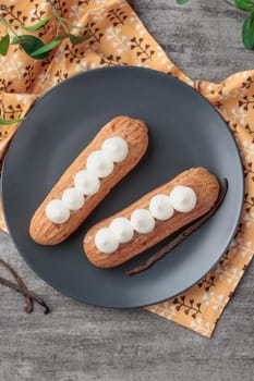Traditional French dessert sweet eclairs on a gray background