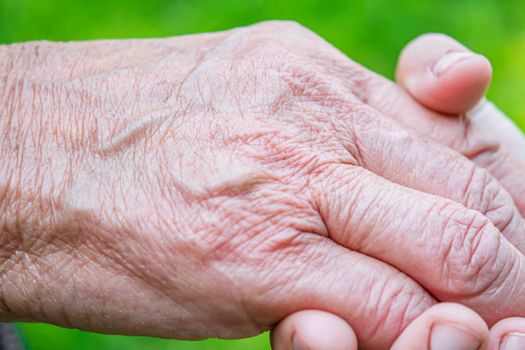 old man holding child's hands. selective focus people