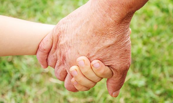 old man holding child's hands. selective focus.People