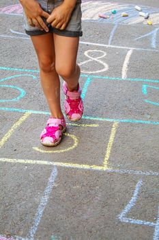 Child jumping classics on the pavement. Selective focus.child