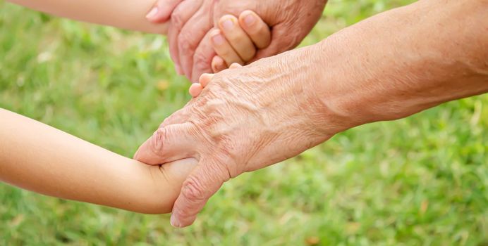 old man holding child's hands. selective focus.People