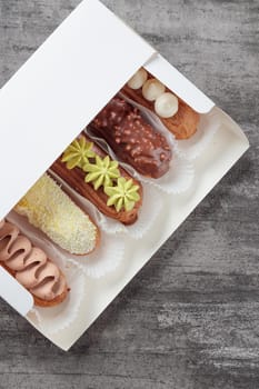 Set of French dessert sweet eclairs on a gray background