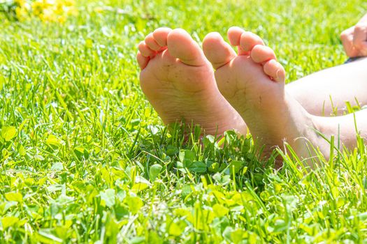 Child lying on green grass. Kid having fun outdoors in spring park. Selective focus. people