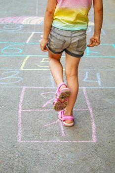Child jumping classics on the pavement. Selective focus.child