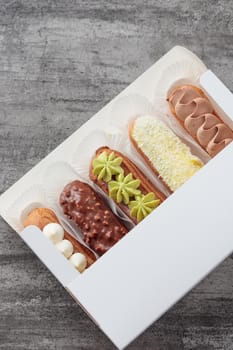 Set of French dessert sweet eclairs on a gray background