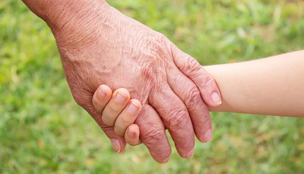 old man holding child's hands. selective focus.People