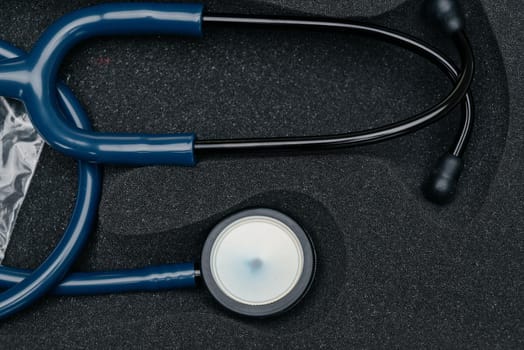 Medical stethoscope. Blue medical stethoscope.The concept of healthcare.Stethoscope on a dark background