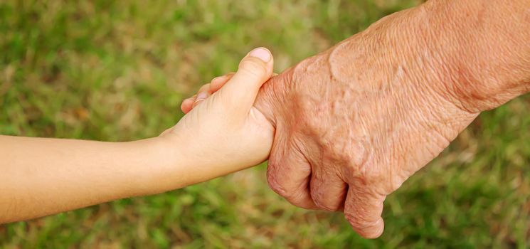 old man holding child's hands. selective focus.People