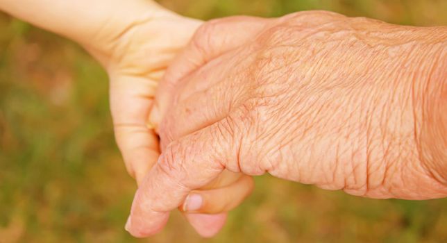 old man holding child's hands. selective focus.People