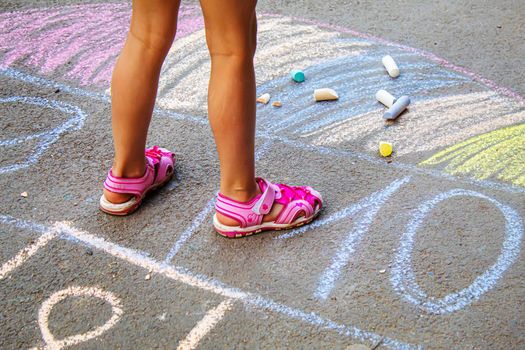 Child jumping classics on the pavement. Selective focus.child