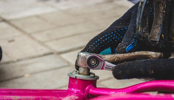 A father repairs his daughter's bike. selective focus
