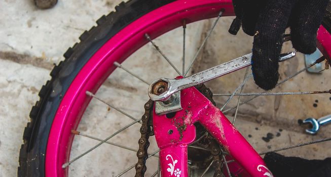 A father repairs his daughter's bike. selective focus