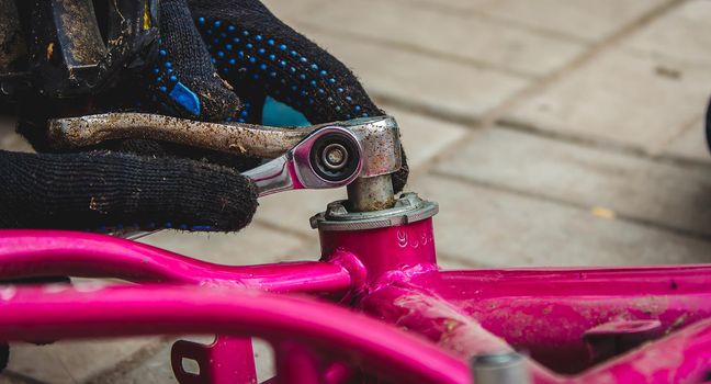 A father repairs his daughter's bike. selective focus