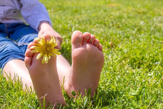 Child lying on green grass. Kid having fun outdoors in spring park. Selective focus. people