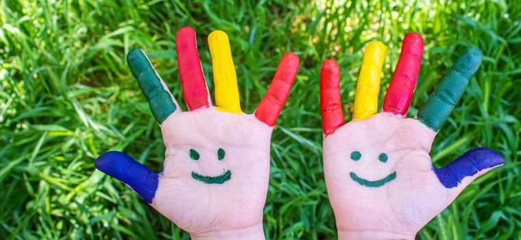 Children's hands in the colors of summer. Selective focus.nature