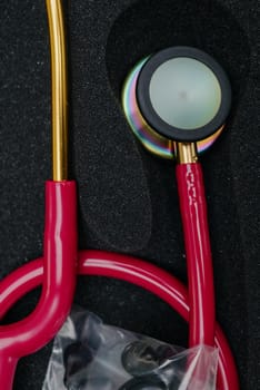 Medical stethoscope. Red medical stethoscope.The concept of healthcare.Stethoscope on a dark background