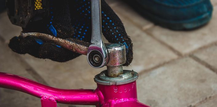 A father repairs his daughter's bike. selective focus