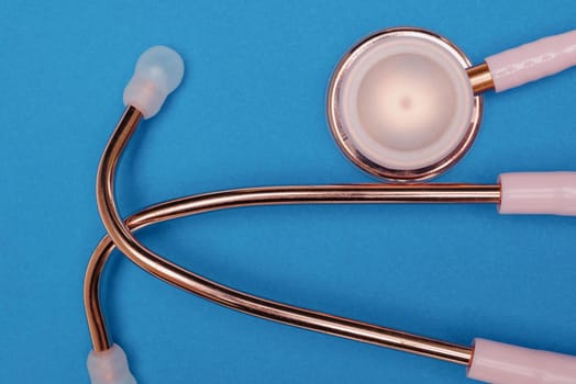 Medical stethoscope.Pink medical stethoscope.The concept of healthcare.Stethoscope on a blue background