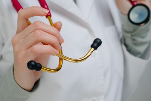 Red medical stethoscope.A doctor with a stethoscope.A doctor holding a stethoscope.The concept of healthcare.