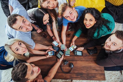 Top view hands circle using phone in cafe - Multiracial friends mobile addicted interior scene from above - Wifi connected people in bar table meeting - Concept of teamwork.