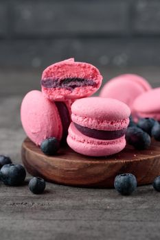 Pink macaroons on a grey concrete background. Vertical