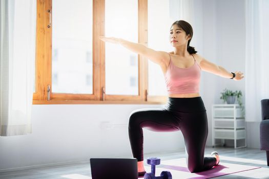 stress relief, muscle relaxation, breathing exercises, exercise, meditation, portrait of Young Asian woman relaxing her body from office work by practicing yoga by watching online tutorials