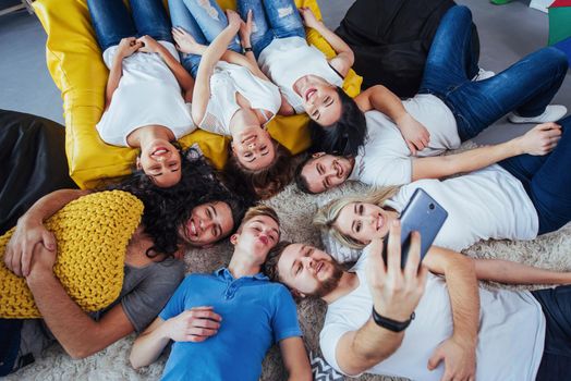 Group beautiful young people doing selfie lying on the floor, best friends girls and boys together having fun, posing emotional lifestyle people concept.