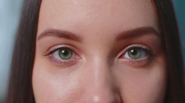 Close-up macro portrait of beauty young beautiful woman's eyes, smiling looking at camera. Gray brown eyes of woman face, girl female model. Lady opening blinking her eyes. Slow motion 4k footage