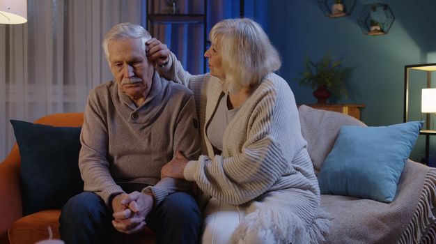 Senior man sit with wife indoors feels upset, loving woman put hand on shoulders hugs him comforting, express empathy, close-up. Potency health problems, crisis, impotence, incurable disease concept