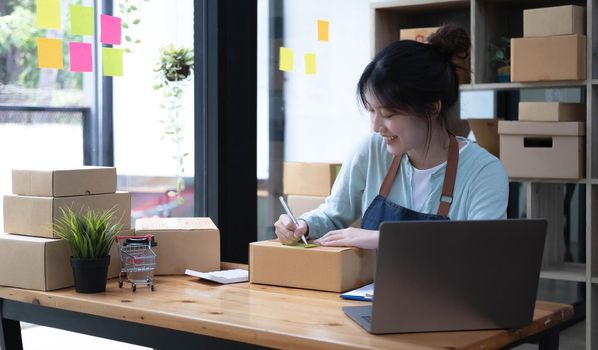 Starting small businesses SME owners female entrepreneurs Write the address on receipt box and check online orders to prepare to pack the boxes, sell to customers, sme business ideas online..