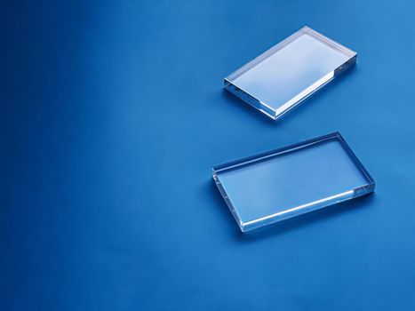 Transparent glass device on blue background, future technology and abstract screen mockup design concept