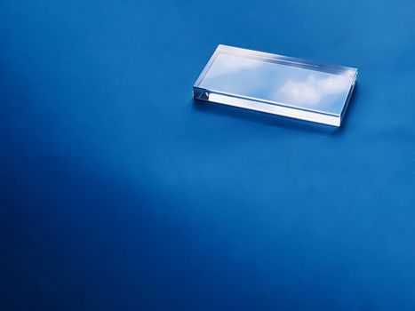 Transparent glass device on blue background, future technology and abstract screen mockup design concept