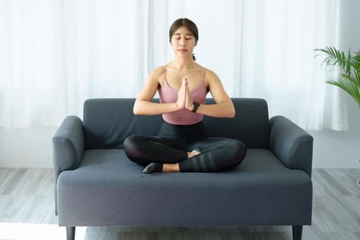 stress relief, muscle relaxation, breathing exercises, exercise, meditation, portrait of Young Asian woman relaxing her body from office work by practicing yoga by watching online tutorials