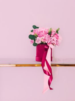 Beautiful bouquet of blooming flowers in flower box on pink background, holiday gift, luxury floral design concept